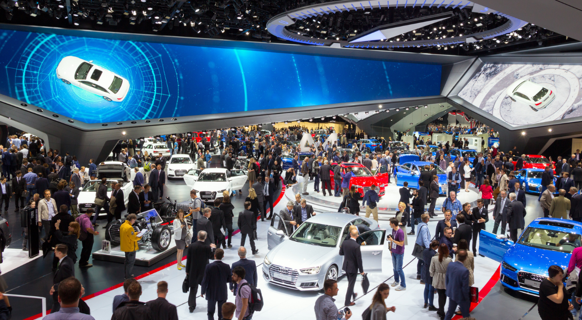 Journalists, attendees and cars on the show floor at an automotive event